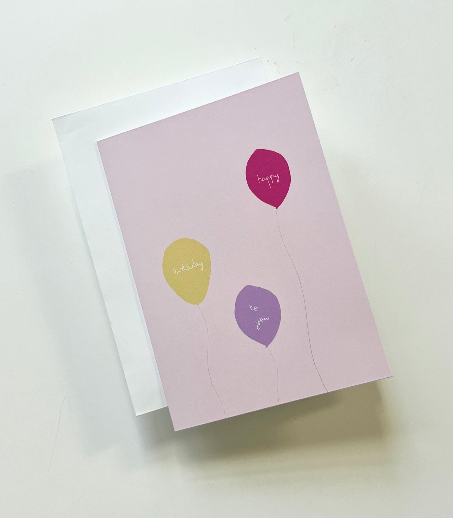 hand drawn pink greeting card with a yellow, purple, and pink ballon that says happy birthday to you.