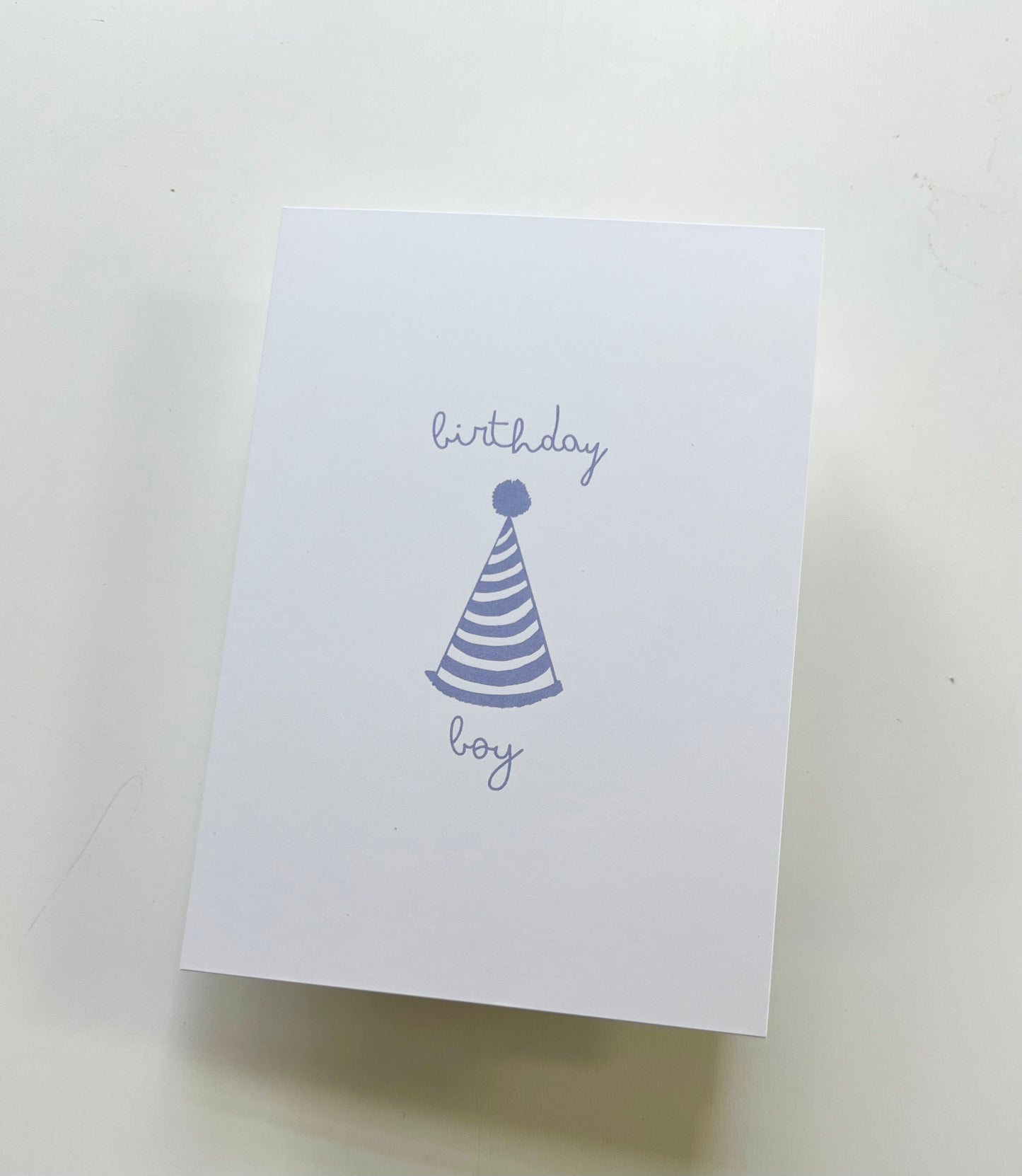 hand drawn happy birthday greeting card with blue party hat that says birthday boy.