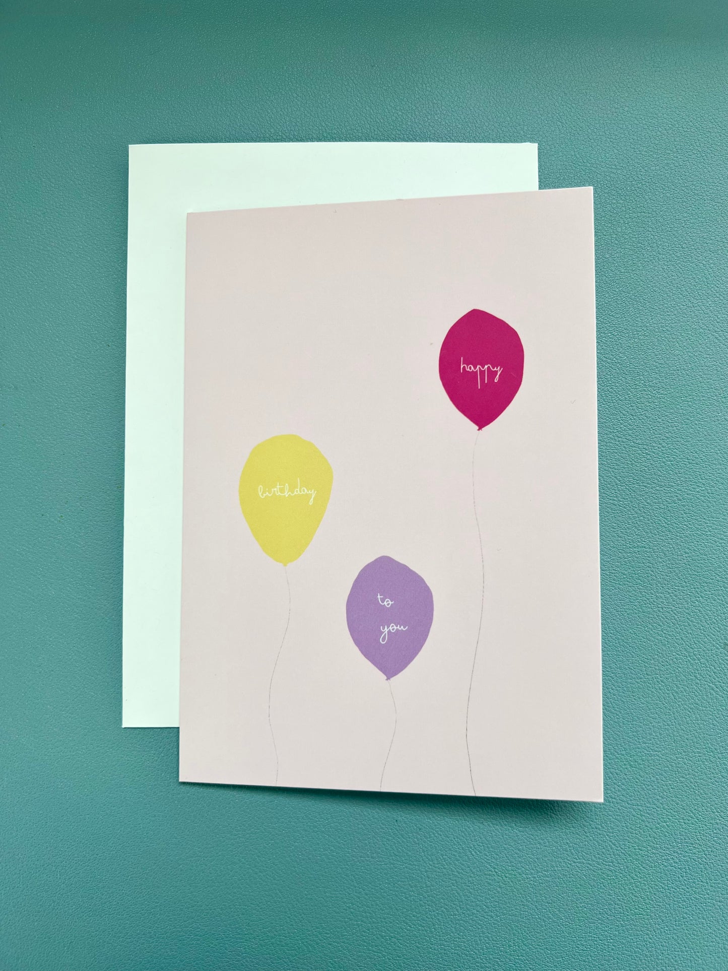 hand drawn pink greeting card with a yellow, purple, and pink ballon that says happy birthday to you.
