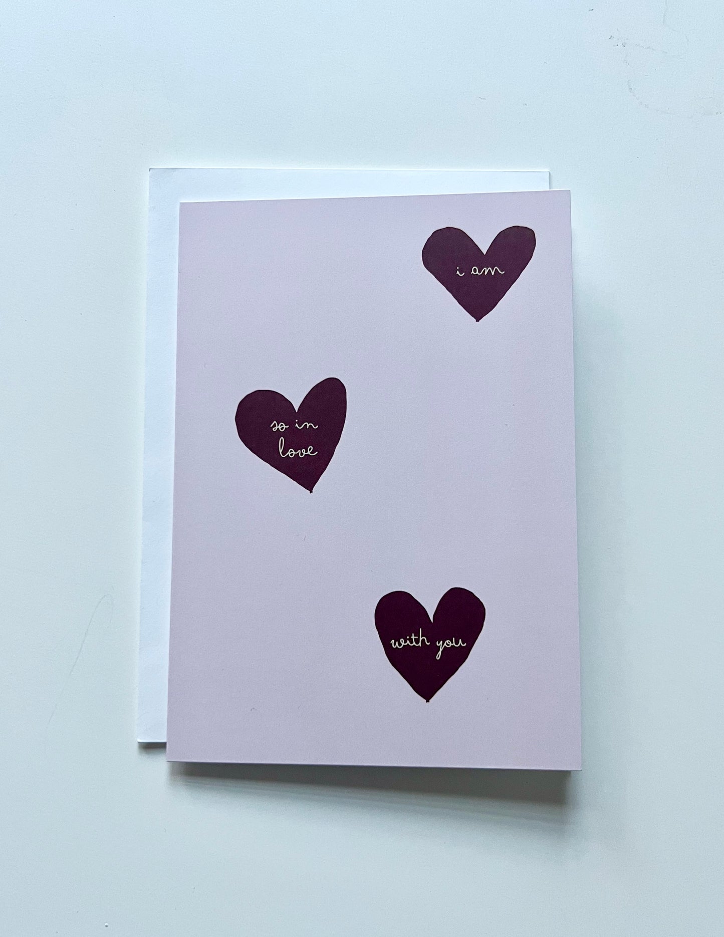 hand drawn pink greeting card with red hearts that says i am so in love with you.