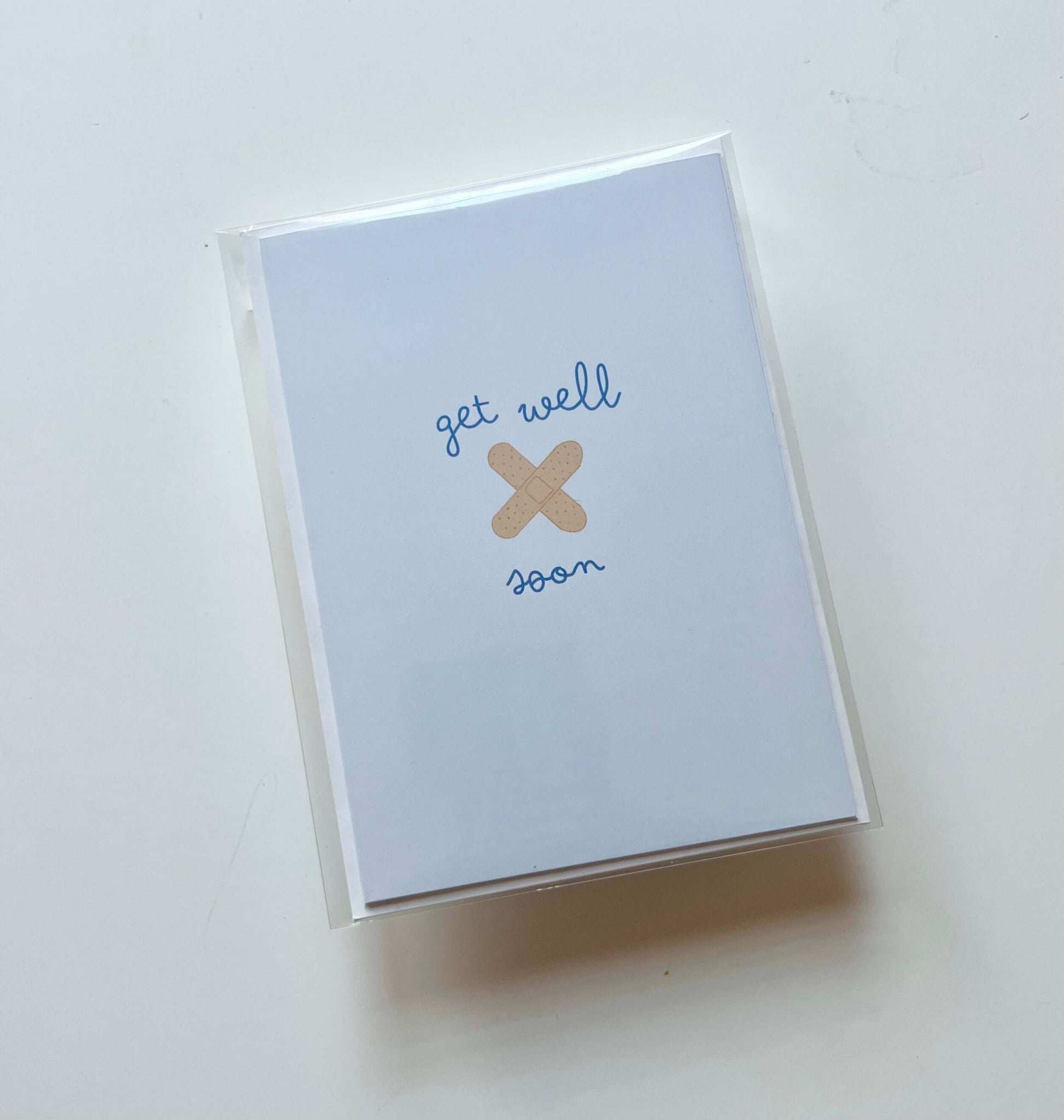 hand drawn blue get well soon greeting card with you crossed bandaids.