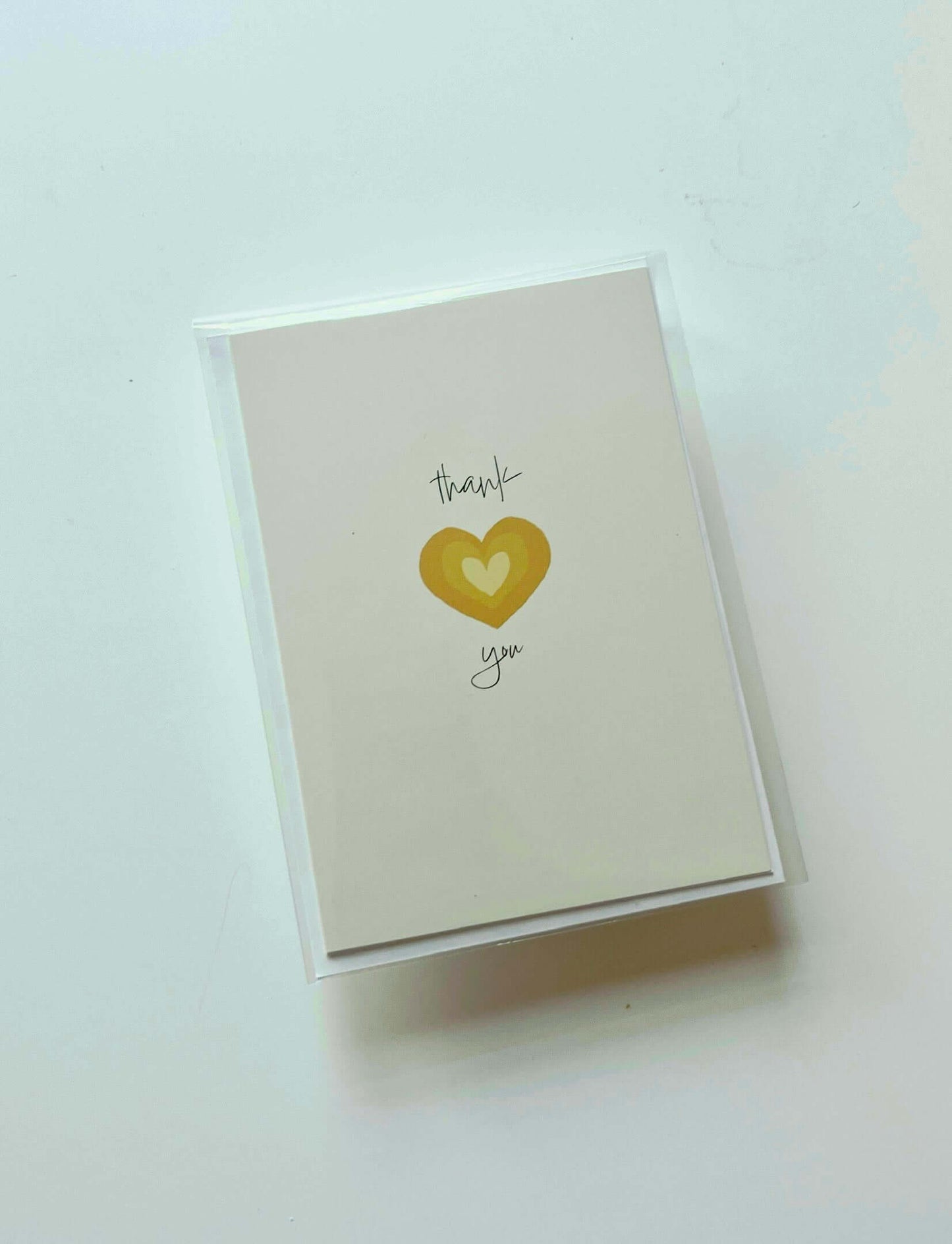 hand drawn yellow heart greeting card that says thank you in cursive.