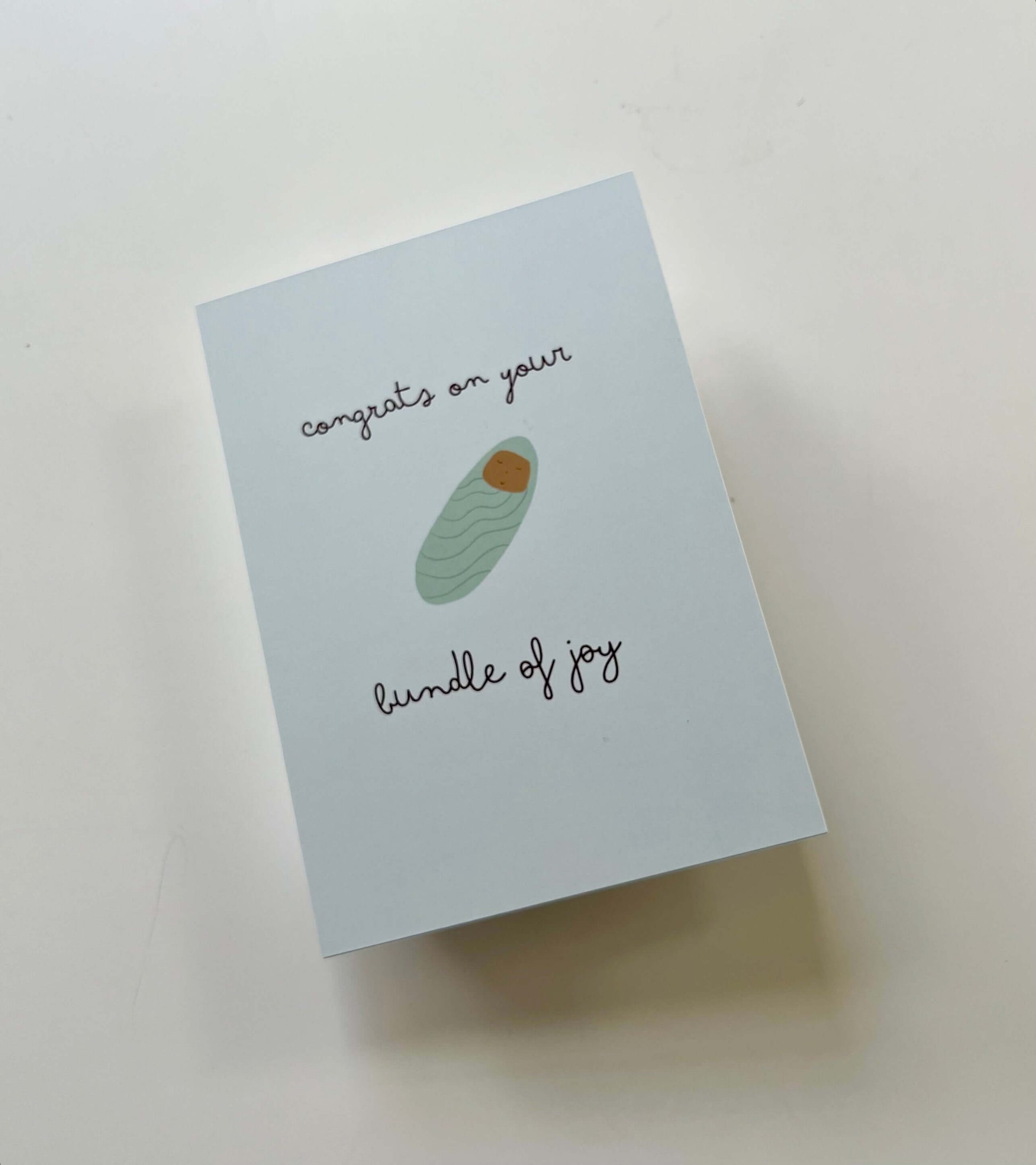 hand drawn green new baby greeting card that says congrats on your bundle of joy.