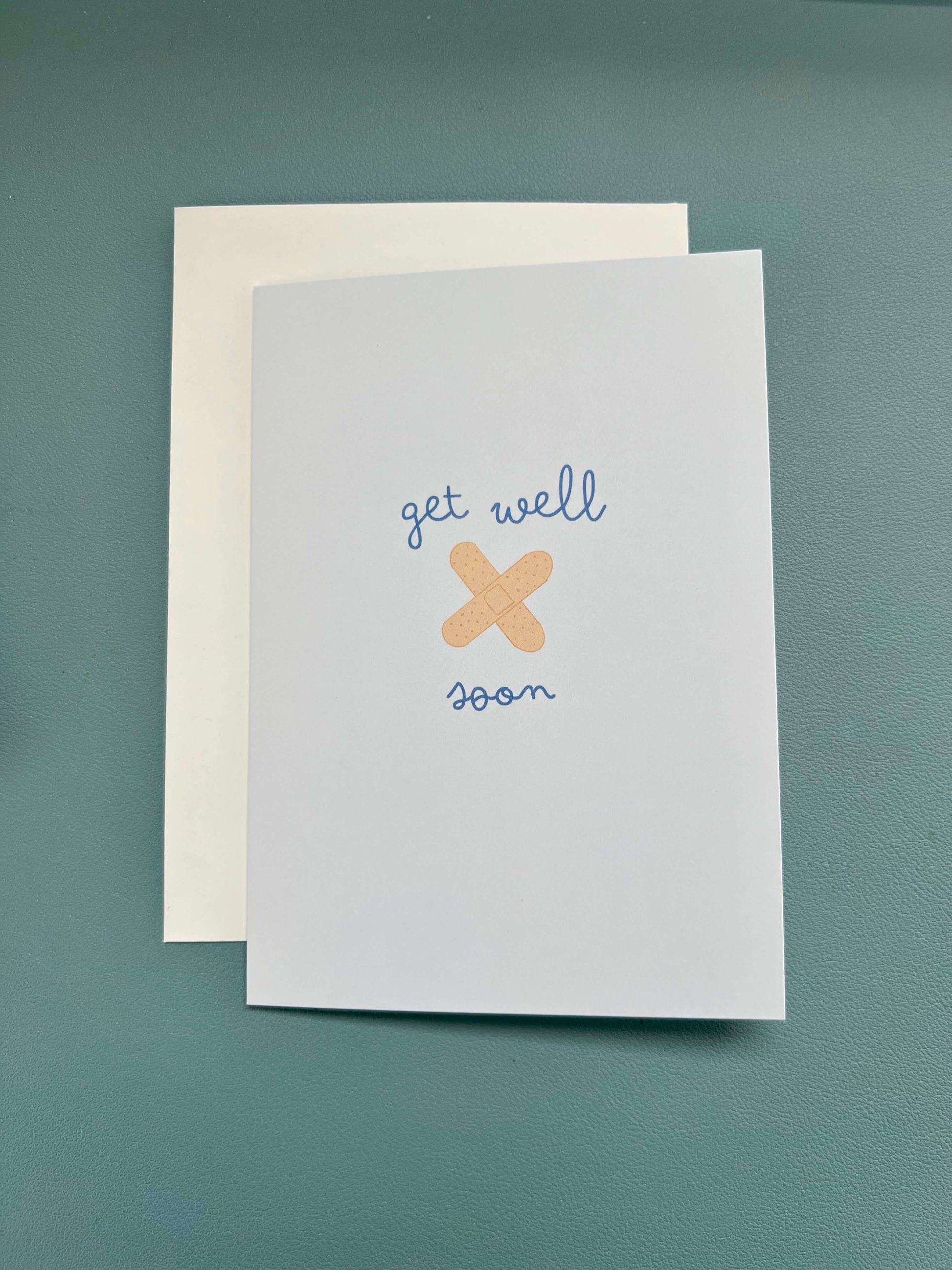 hand drawn blue get well soon greeting card with you crossed bandaids.